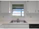 Bright kitchen features a double sink, dishwasher, and window with a water view at 405 W 4Th Ct, Frostproof, FL 33843