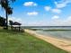 Scenic lakeside gazebo with sandy beach and grassy area at 405 W 4Th Ct, Frostproof, FL 33843