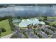 An aerial view of a community clubhouse, pool, parking, basketball and tennis courts overlooking a large lake at 4104 Martindale Loop, Winter Haven, FL 33884