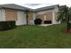 Backyard with privacy, showcasing storm shutters, outdoor grill, and lush green lawn at 4104 Martindale Loop, Winter Haven, FL 33884