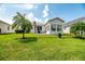 Spacious backyard with grassy lawn, palm trees, and a patio at 4104 Martindale Loop, Winter Haven, FL 33884