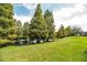 Scenic backyard view featuring mature trees, lush green grass, and a serene pond at 4104 Martindale Loop, Winter Haven, FL 33884