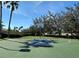 Outdoor basketball court with blue and green surfacing, surrounded by green trees and bushes under a clear blue sky at 4104 Martindale Loop, Winter Haven, FL 33884