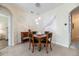 Cozy dining area with a square wooden table, black chairs, modern pendant lighting, and tile flooring at 4104 Martindale Loop, Winter Haven, FL 33884