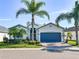 House exterior with gray garage door and palm trees at 4104 Martindale Loop, Winter Haven, FL 33884