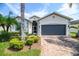 Charming single-story home featuring a two-car garage, beautiful landscaping and a brick paved driveway at 4104 Martindale Loop, Winter Haven, FL 33884