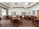 Cozy game room with several round tables and chairs, decorated with floral wallpaper, and featuring ceiling fans at 4104 Martindale Loop, Winter Haven, FL 33884