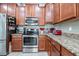 A well-equipped kitchen with stainless steel appliances, granite countertops, and tile backsplash at 4104 Martindale Loop, Winter Haven, FL 33884