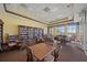 Bright library with large bookcase, tables, chairs, and a comfortable seating area in a well-lit setting at 4104 Martindale Loop, Winter Haven, FL 33884