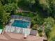 Aerial view of the property featuring a pool, fire pit area, patio, and lush landscaping at 3808 Gaines Dr, Winter Haven, FL 33884