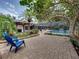 Spacious outdoor patio area with brick pavers, landscaping, and access to the pool and outdoor kitchen at 3808 Gaines Dr, Winter Haven, FL 33884