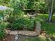 Aerial view of the backyard featuring a lush garden, fire pit, and stone walkway at 3808 Gaines Dr, Winter Haven, FL 33884