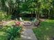 Landscaped backyard features a brick fire pit and colorful Adirondack chairs, perfect for outdoor entertaining at 3808 Gaines Dr, Winter Haven, FL 33884