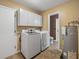 Functional laundry room equipped with modern washer and dryer and ample storage cabinets at 3808 Gaines Dr, Winter Haven, FL 33884