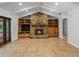 Cozy living room boasting a stone fireplace, built-in cabinets, beamed ceiling, and tiled floors at 3808 Gaines Dr, Winter Haven, FL 33884