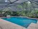 A refreshing pool surrounded by lush tropical landscaping and an elegant screen enclosure at 3808 Gaines Dr, Winter Haven, FL 33884