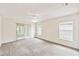 Spacious bedroom featuring neutral carpet, a ceiling fan, and natural light through sliding glass door and windows at 142 Morning Glory Cir, Winter Haven, FL 33884
