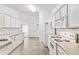 Functional kitchen boasts white cabinetry, essential appliances, and tile flooring for easy maintenance at 142 Morning Glory Cir, Winter Haven, FL 33884