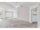Open living space featuring ample light, a ceiling fan, and an adjacent hallway leading to the kitchen at 142 Morning Glory Cir, Winter Haven, FL 33884