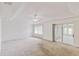 Expansive main bedroom with neutral carpet, tray ceiling, ceiling fan, and sliding door to a screened porch at 142 Morning Glory Cir, Winter Haven, FL 33884