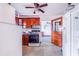 Kitchen with wood cabinets, stove, and access to the living area at 605 Florida Ave, Dundee, FL 33838