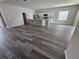 Open-concept living area featuring hardwood floors and a modern kitchen with stainless steel appliances at 991 First Dr, Eagle Lake, FL 33839