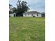 Large backyard with a storage shed, green grass, and rear view of the home at 720 S Morrison Ave, Fort Meade, FL 33841
