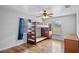 Bedroom featuring a bunkbed, hardwood floors, dresser, ceiling fan, blue curtains, and windows at 720 S Morrison Ave, Fort Meade, FL 33841