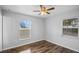 Bright bedroom with wood-look floors, ceiling fan, and two windows at 720 S Morrison Ave, Fort Meade, FL 33841