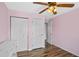 Cozy bedroom with hardwood floors, ceiling fan, two white closets, and a connecting door at 720 S Morrison Ave, Fort Meade, FL 33841