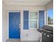 Bright blue front door with matching shutters and a grill on the porch at 720 S Morrison Ave, Fort Meade, FL 33841