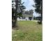 View of the front yard, single-story home, and driveway, surrounded by trees at 720 S Morrison Ave, Fort Meade, FL 33841