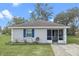 Charming single-story home with blue shutters and a screened front porch entry at 720 S Morrison Ave, Fort Meade, FL 33841