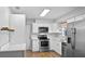 Well-lit kitchen featuring stainless steel appliances, white cabinetry, and wood-look flooring at 720 S Morrison Ave, Fort Meade, FL 33841