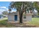 Side view of a gray house with a blue door and mature tree in the yard at 720 S Morrison Ave, Fort Meade, FL 33841