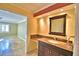 Bathroom with dark wood cabinets, granite countertops, with view into bedroom through doorway at 579 Saint Andrews Rd, Winter Haven, FL 33884