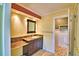 Bathroom featuring granite countertops, dark wood cabinets, and a tiled shower stall with glass door at 579 Saint Andrews Rd, Winter Haven, FL 33884