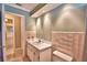 Well-lit bathroom featuring a single sink vanity and pink ceramic tiling at 579 Saint Andrews Rd, Winter Haven, FL 33884