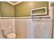 Bathroom with tiled walls, a toilet, and decorative border at 579 Saint Andrews Rd, Winter Haven, FL 33884