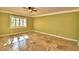 Spacious bedroom featuring tiled flooring with a decorative design, ceiling fan, and shuttered window at 579 Saint Andrews Rd, Winter Haven, FL 33884