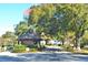 View of the secure gated entrance to the community featuring an American flag and mature trees at 579 Saint Andrews Rd, Winter Haven, FL 33884