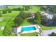 Overhead shot of the community pool and clubhouse amidst lush greens with views of the golf course and neighborhood at 579 Saint Andrews Rd, Winter Haven, FL 33884