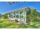 View of the back of the house, featuring an enclosed porch, landscaping, and well-maintained lawn at 579 Saint Andrews Rd, Winter Haven, FL 33884