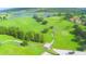 Aerial view of the verdant golf course, dotted with trees, ponds, and winding paths for golf carts, offering a scenic landscape at 579 Saint Andrews Rd, Winter Haven, FL 33884