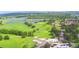 Overhead view of a lush golf course with winding paths, ponds, and the clubhouse amidst a neighborhood with mature trees at 579 Saint Andrews Rd, Winter Haven, FL 33884