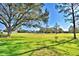 Scenic view of the golf course featuring lush green grass and mature trees under a sunny blue sky at 579 Saint Andrews Rd, Winter Haven, FL 33884