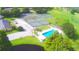 Aerial view of the community featuring tennis courts and a pool surrounded by lush landscaping and well-maintained grounds at 579 Saint Andrews Rd, Winter Haven, FL 33884