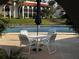 View from the patio of the community pool area with table and chairs under umbrellas at 6001 Country Club Dr, Lake Wales, FL 33898