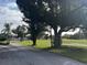 Community street view with mature trees and green space in the background at 6001 Country Club Dr, Lake Wales, FL 33898