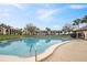 Large swimming pool with well-manicured landscaping and beautiful community buildings in the backdrop at 6001 Country Club Dr, Lake Wales, FL 33898